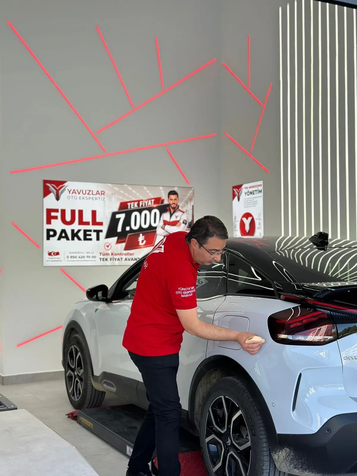 Yavuzlar oto ekspertiz istasyonu — eksper aracın boya ve kaporta kontrolünü yaparken